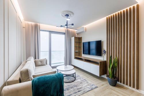 a living room with a couch and a tv at Balticus Apartamenty Deluxe Promenada Gwiazd 14 in Międzyzdroje
