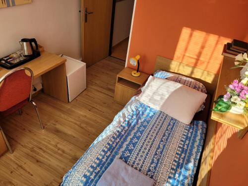 a small room with a bed and a desk at Hotel Gól Prostějov in Prostějov