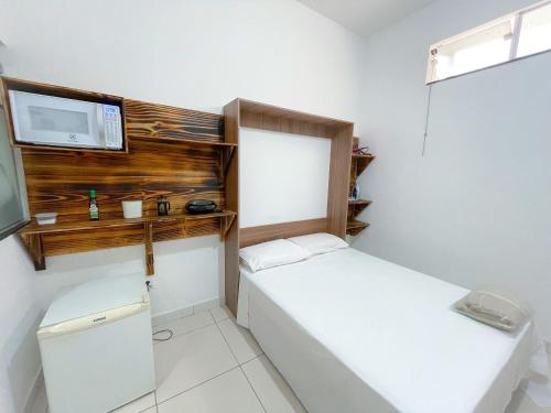 a small room with two beds and a tv at Suíte aconchegante no Centro de Caratinga - kitnet in Caratinga