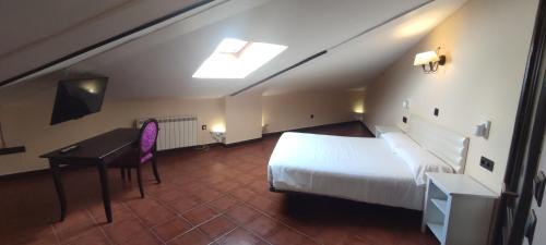 a bedroom with a bed and a desk in a room at La Posada De La Magistral in Alcalá de Henares