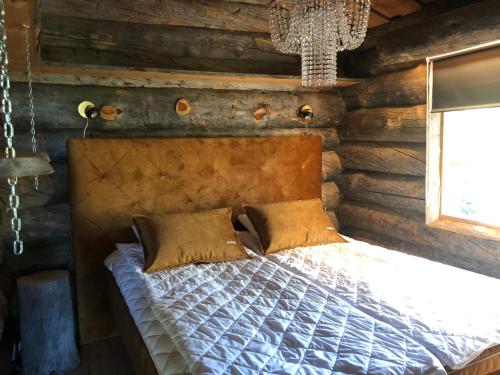 una camera con un letto in una baita di tronchi di Arcticvillas Tunturituikku a Kemijärvi