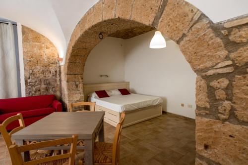 Habitación con cama, mesa y sofá en Appartamento per Vacanza La Fontanella, en Orvieto