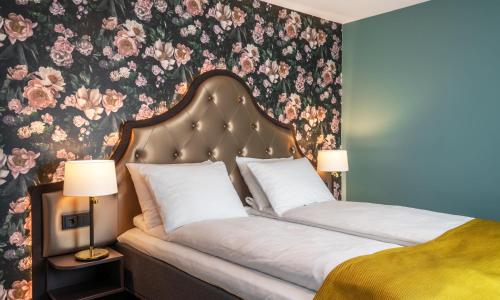 a bedroom with a bed with a floral wallpaper at Thon Hotel Høyers in Skien