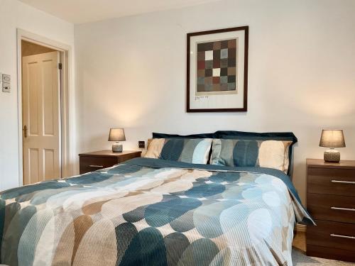 a bedroom with a bed with two night stands and two lamps at 8 Oakridge, St Mellion in St. Mellion