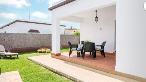 een patio met een tafel en stoelen in een tuin bij Casa Colada 3 in Conil de la Frontera