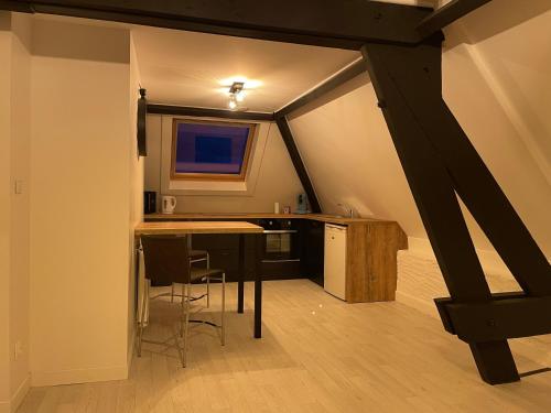 a kitchen with a table and chairs in a attic at Le petit paradis in Outreau