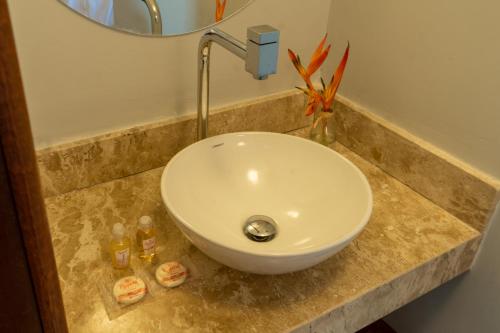 a white sink in a bathroom with a mirror at Tropical Beach in Porto Seguro