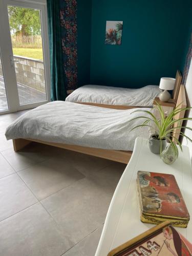 two beds in a room with a table and a window at Gîte de la Chapelle in Samart