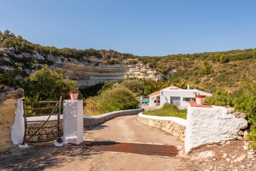 a dirt road with a house on a hill at Villa Es Torrent Verd in Alaior