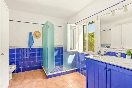Baño azul con lavabo y aseo en Villa Es Torrent Verd, en Alaior