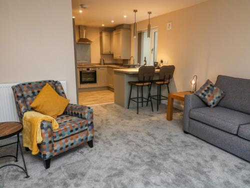 a living room with a couch and a kitchen at Market Lounge in Clitheroe
