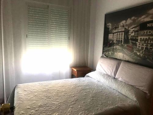 sypialnia z łóżkiem i oknem z narzutą w obiekcie Costamar, Primera linea de playa, 3 dormitorios, 2 baños, vistas al mar, Internet Wifi y Garaje, Ideal parejas y familias w mieście Benalmádena