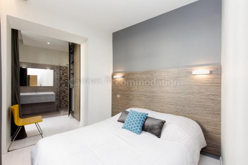 une chambre avec un lit blanc et une chaise jaune dans l'établissement Clic 20, à Cannes