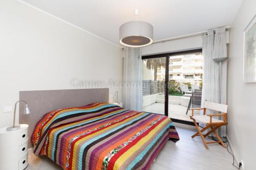 - une chambre avec un lit et une couverture rayée colorée dans l'établissement Louis 2, à Cannes