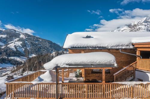 a log cabin with snow on the roof at Das Chalet. in Mühlbach am Hochkönig