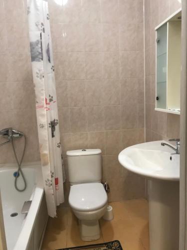 bagno con servizi igienici bianchi e lavandino di Гостиница Райхан a Atyraū