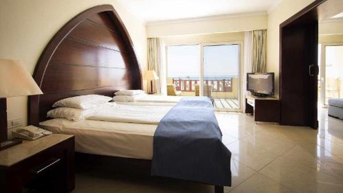 a hotel room with a large bed and a television at Robinson Soma Bay in Hurghada