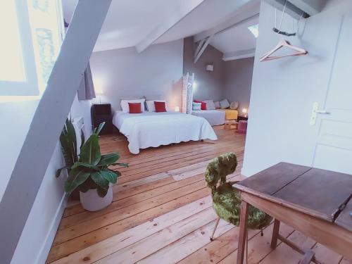 Un dormitorio con 2 camas y una mesa en una habitación en La maison botanique, en Castillon-la-Bataille