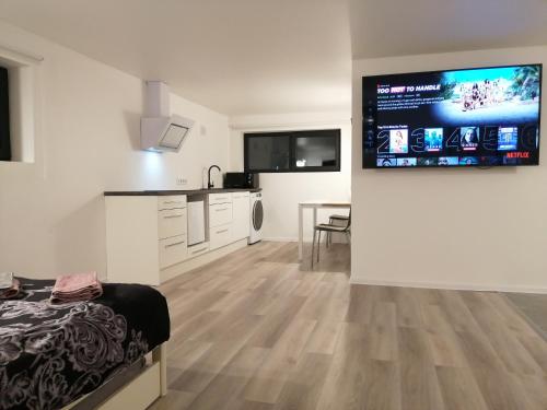a room with a bed and a large screen on the wall at Luxury Apartment Private House and Parking Netflix in Tartu