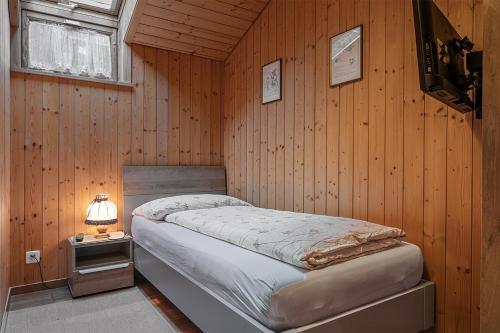 a bedroom with a bed in a wooden wall at Hotel-Restaurant Drei Tannen in Niederwald