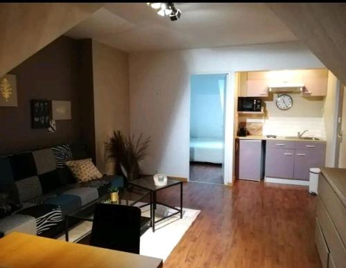 a living room with a couch and a table at Appartement calme aux portes de Rennes in Vezin-le-Coquet