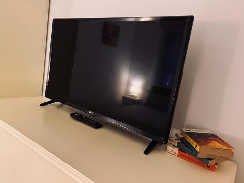 a television sitting on a table with a remote control at Apartament Aretta in Braşov