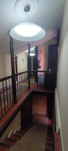 a hallway with a staircase with a large light at La Posada De La Magistral in Alcalá de Henares