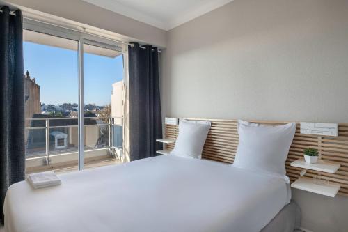- une chambre avec un grand lit blanc et une grande fenêtre dans l'établissement Appartement avec vue sur l'Erdre pour 4 personnes, à Nantes