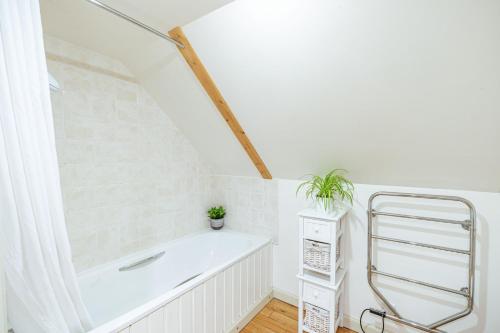 a bathroom with a bath tub in a attic at Penninghame West Lodge in Newton Stewart