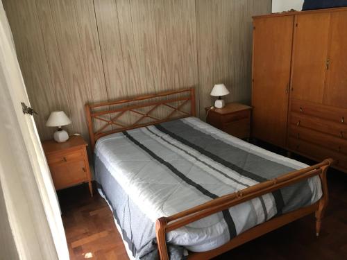 1 dormitorio con 1 cama de madera y 2 mesitas de noche en Lo de Dora en Mar del Plata