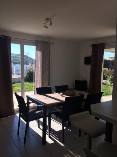 a dining room with a table and chairs and a window at Aux couleurs d’Ardèche in Vallon-Pont-dʼArc