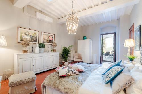 a bedroom with a large bed and a chandelier at Villa Chianti, your Secret 4 Bedrooms Retreat with View over the Vineyards in Marcialla in Marcialla