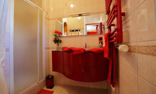 y baño con lavabo rojo y ducha. en Lanévry, Yseult, en Kerlaz