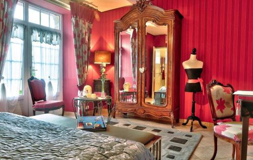 een slaapkamer met rode muren, een spiegel en een bed bij Lanévry, Yseult in Kerlaz
