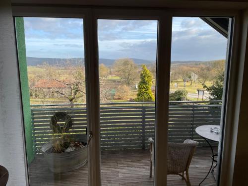 a sliding glass door with a view of a deck at Ferienwohnung Nussbaum-Nest in Hausen