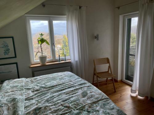 a bedroom with a bed and a window and a chair at Ferienwohnung Nussbaum-Nest in Hausen