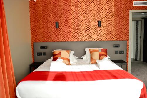 a bedroom with a bed with an orange wall at Best Western Plus Le Fairway Hotel & Spa Golf d'Arras in Anzin-Saint-Aubin