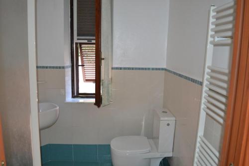 uma casa de banho com um WC, um lavatório e uma janela em Appartamento 2m em Ameglia