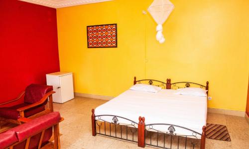a bedroom with a bed and a red and yellow wall at Résidence abdou diouf in Dakar