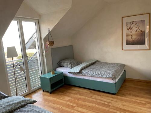a small bedroom with a bed and a balcony at Ferienwohnung Nussbaum-Nest in Hausen