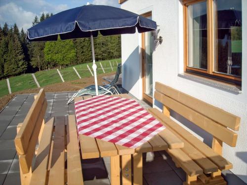 einen Picknicktisch und einen Regenschirm auf einer Terrasse in der Unterkunft Holiday Home Auer - EBE115 by Interhome in Eben im Pongau