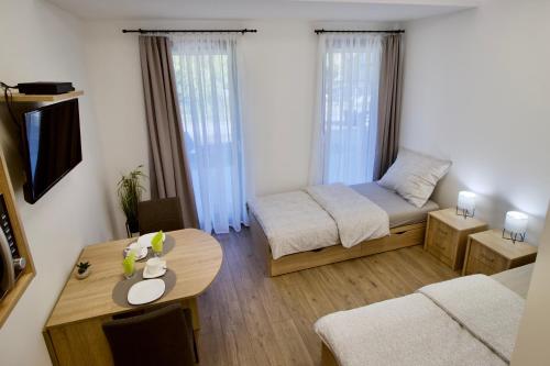 mały salon z łóżkiem i stołem w obiekcie Sport Centrum Apartman w mieście Pápa