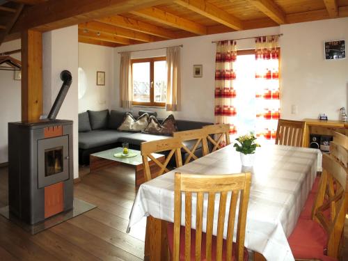 ein Wohnzimmer mit einem Tisch und einem Holzofen in der Unterkunft Holiday Home Auer - EBE115 by Interhome in Eben im Pongau