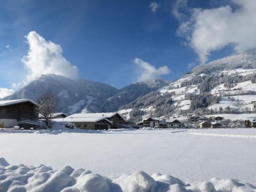 a snow covered village with mountains in the background at Chalet Heisenhaushütte by Interhome in Ramsau im Zillertal