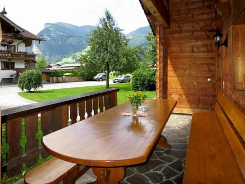 una mesa de madera en el balcón de una cabaña en Chalet Heisenhaushütte - MHO684 by Interhome, en Ramsau im Zillertal