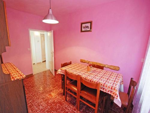 uma sala de jantar com uma mesa e uma parede rosa em Apartment La Busa-1 by Interhome em Masarè