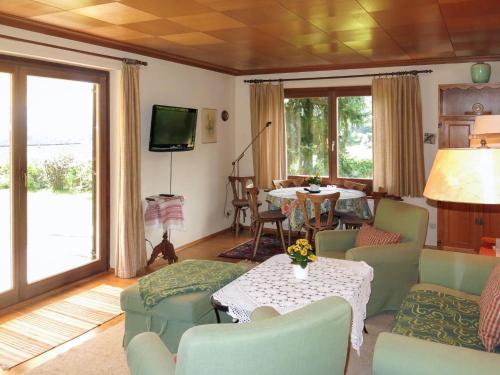 a living room with a table and chairs and a television at Holiday Home Reier by Interhome in Seeboden