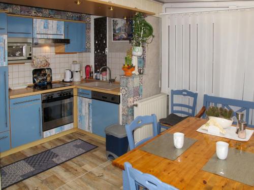 a kitchen with blue cabinets and a wooden table at Holiday Home Heike by Interhome in Wandlitz