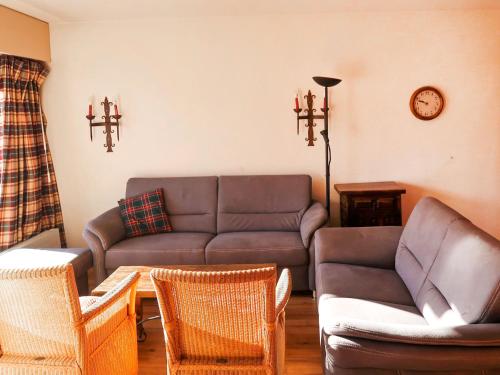 ein Wohnzimmer mit einem Sofa und Stühlen in der Unterkunft Apartment Bouleaux I4 by Interhome in Nendaz