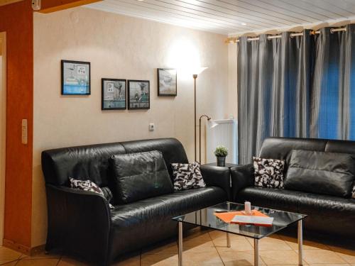 オッテルンドルフにあるHoliday Home Fritz by Interhomeのリビングルーム(黒い革張りのソファ2台、テーブル付)